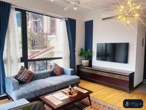 uma sala de estar com um sofá e uma televisão de ecrã plano em High-ser Apartment -2BR - NiceView - Parking - Spacious - In center em Hanói