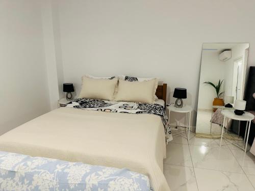 1 dormitorio blanco con 1 cama blanca grande con almohadas en Studio Doulapas, en Chrani