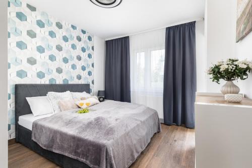a bedroom with a bed with a blue and white wall at Apartments with Parking - Klimaty Baltyku by Renters in Dziwnów