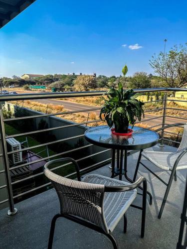 a table with a potted plant on a balcony at The Abode in Gaborone