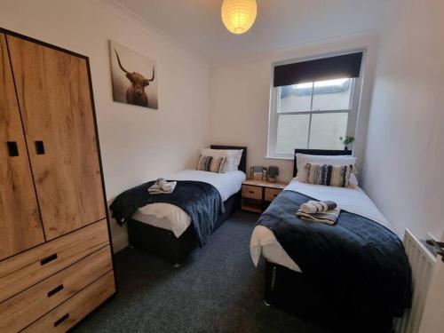 1 dormitorio con 2 camas y una foto de ciervo en la pared en Spacious Homey Gem Minutes to the Beach w/Garden en Seascale