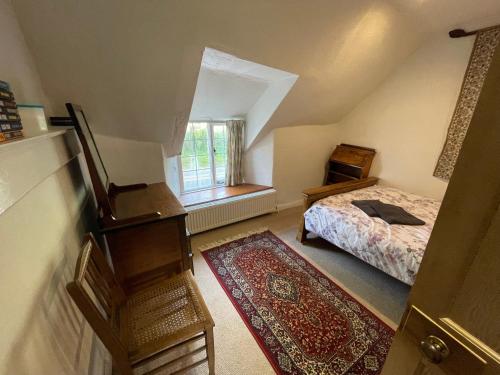 a small bedroom with a bed and a window at Lovely listed cottage in old centre with garden. in Oundle