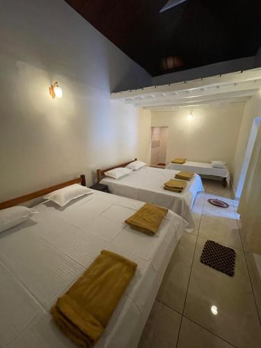 a room with two beds with towels on them at The Estate HomeStay in Attigundi