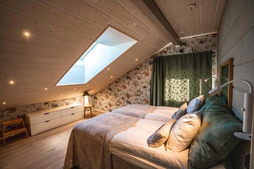 a bedroom with a large bed and a skylight at Villa Pöylikki in Rovaniemi
