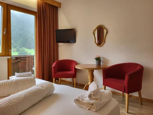 um quarto de hotel com uma cama e duas cadeiras e uma mesa em Pension Terra em Neustift im Stubaital