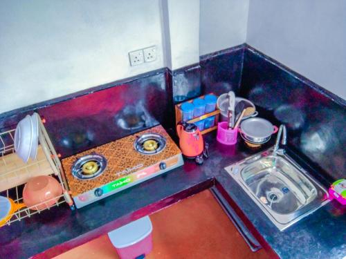 a small kitchen with a stove and a sink at Bloom Guest House in Mirissa