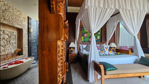 a bedroom with a bed and a bathtub and a bedroom with a bathtub at Ubud Paradise Villa in Ubud