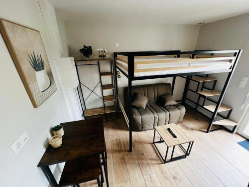 トレガステルにあるStudio cosy à Trégastelの二段ベッドとテーブルが備わる小さな客室です。