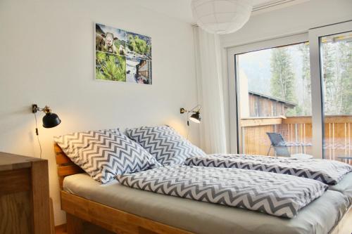 a bed with pillows on it in a room with a window at Apartment Arvenwald in Kandersteg