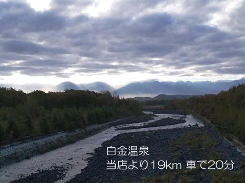 a river with writing on the side of it at カフェロッジ Touch Wood in Biei