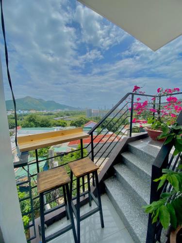 a balcony with two chairs and a table and some flowers at Homestay Tuyết Trinh in Nha Trang