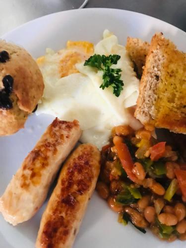 a plate of food with eggs and beans and bread at Jayla Apartment in Maun