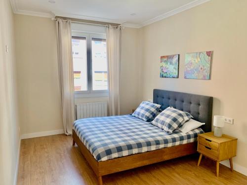 1 dormitorio con 1 cama con sábanas blancas y azules en URDAIHOME, en Guernica y Luno