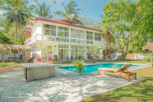 a large house with a swimming pool in front of it at CJ's House at Mawella in Mawella