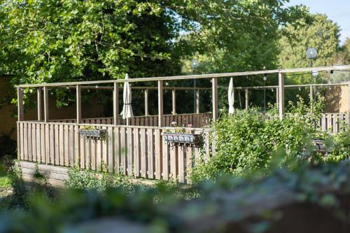 a wooden fence with umbrellas in a garden at Good Morning+ Malmö in Malmö