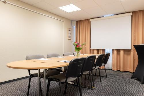 a conference room with a table and chairs and a whiteboard at Good Morning+ Malmö in Malmö