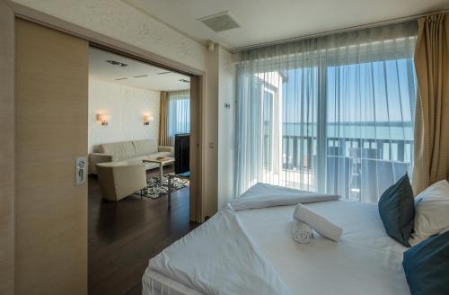 - une chambre avec un lit et une grande fenêtre dans l'établissement Echo Residence All Suite Hotel, à Tihany