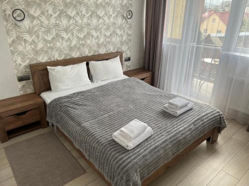 a bedroom with a bed with two towels on it at Готель «У Батька» in Truskavets