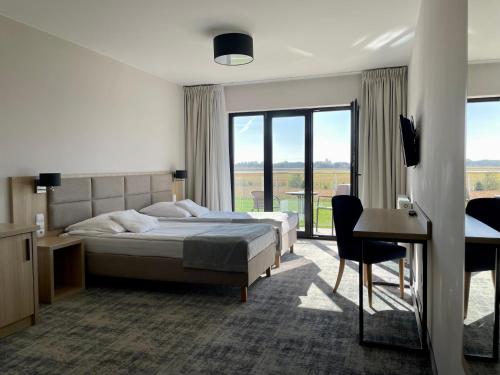 a bedroom with two beds and a desk and a window at Gościniec Uniejów in Uniejow