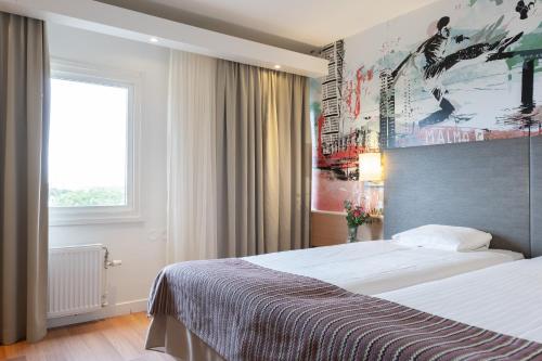 a hotel room with a large bed and a window at Good Morning+ Malmö in Malmö