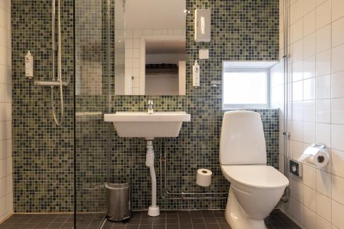 a bathroom with a toilet and a sink and a shower at Good Morning+ Malmö in Malmö