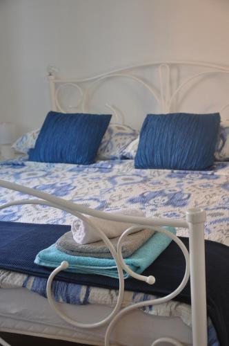 a bed with blue pillows and blue towels on it at Apartman Mirna in Rovinj