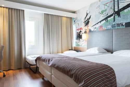 um quarto de hotel com duas camas e uma janela em Good Morning+ Malmö em Malmo