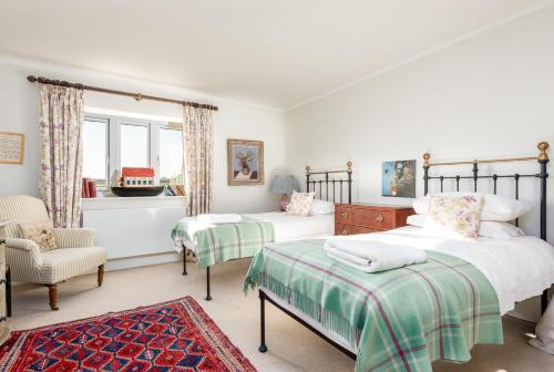 1 dormitorio con 2 camas y 1 silla en Gins Barn, en Southampton