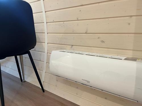 a white appliance sitting next to a chair next to a wall at Helle Aktivitetshotel in Årre