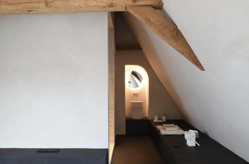 uma casa de banho no sótão com uma parede branca e vigas de madeira em High end private room with private bathroom em Gent
