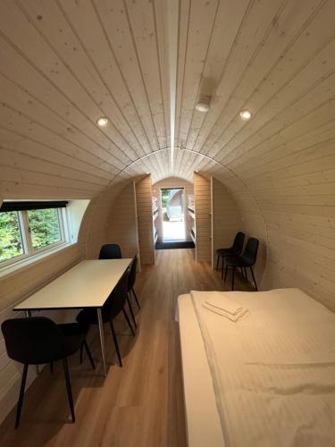 um quarto com uma mesa e cadeiras e uma cama em Helle Aktivitetshotel em Årre