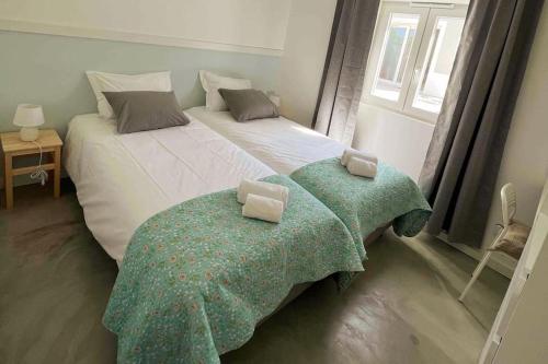 una camera da letto con un letto grande con due cuscini sopra di New Beach House near main street close PraiaGrande a Colares