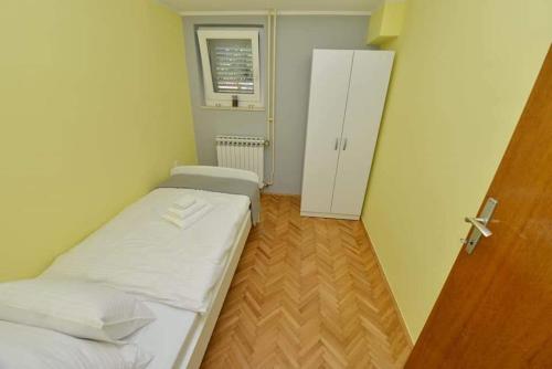 a small room with a bed and a cabinet at D&J Apartment Zadar in Zadar