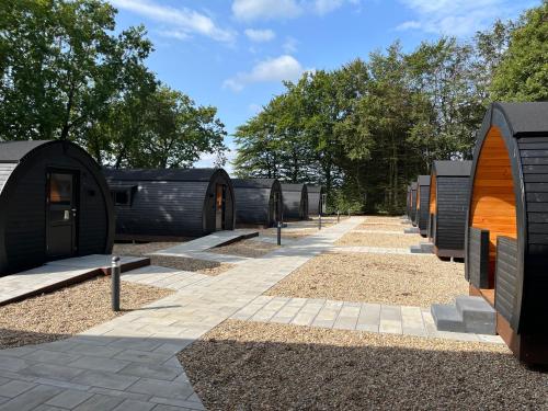 a row of black buildings with trees in the background at Helle Aktivitetshotel in Årre