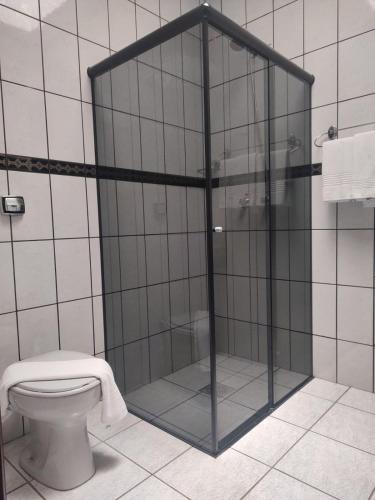 a shower stall in a bathroom with a toilet at Rio Claro Plaza Hotel in Rio Claro