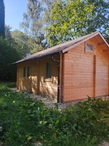 - un petit bâtiment en bois avec une fenêtre dans une cour dans l'établissement Les Chalets de Parly, à Parly