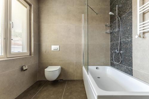 La salle de bains est pourvue d'une baignoire, de toilettes et d'une douche. dans l'établissement Sea View Flat w Balcony Near Beylerbeyi Palace, à Istanbul