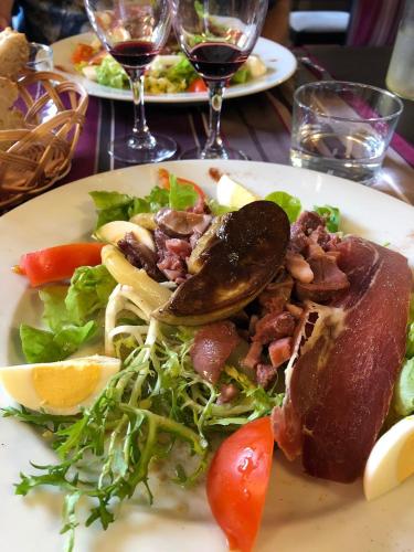 a plate of food with a salad and meat at Kyriad Orthez in Orthez