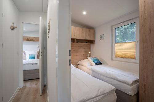 シャルボイツにあるOstseecamp Ferienhaus "Karin"の小さなベッドルーム(ベッド2台、窓付)