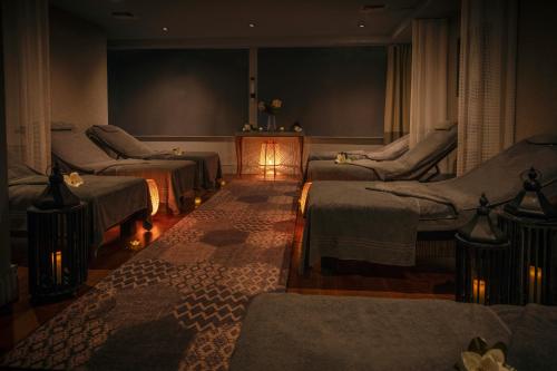 a room with three beds and a lamp in it at Oulton Hall Hotel, Spa & Golf Resort in Leeds