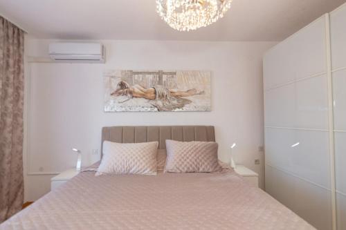 a bedroom with a bed and a chandelier at Apartman Dragomir in Imotski
