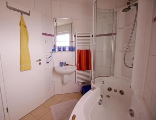 a white bathroom with a tub and a sink at Ataraxia in Insel Poel
