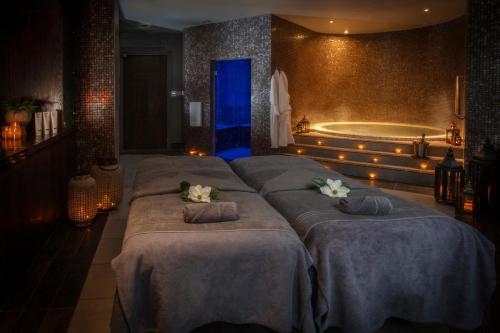 a bedroom with four beds and a bath tub at Oulton Hall Hotel, Spa & Golf Resort in Leeds