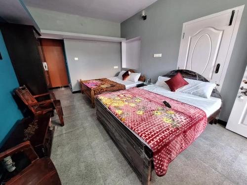 um quarto com 2 camas e 2 cadeiras em Golden View Cottage Ooty em Ooty