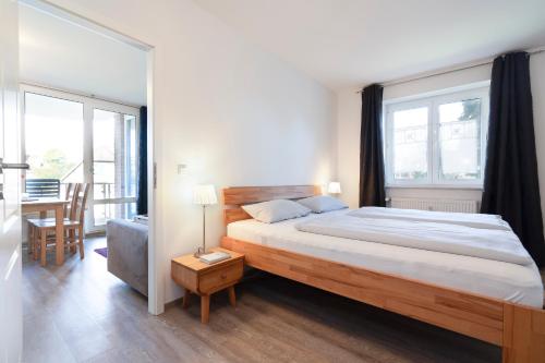1 dormitorio con cama, sofá y ventanas en Wohnpark am Mühlenteich App 14, en Timmendorfer Strand