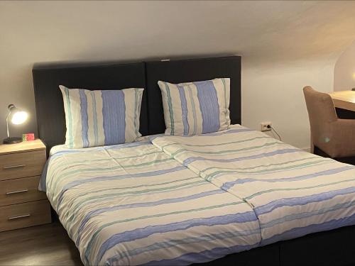 a bed with a blue and white striped comforter at Gretel von Birne in Winterberg
