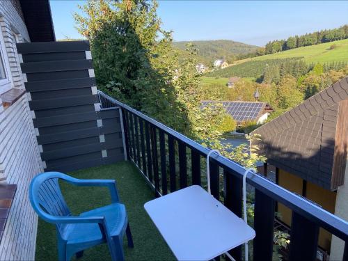 a blue chair and a white table on a balcony at Gretel von Birne in Winterberg