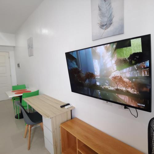 a large flat screen tv hanging on a wall at Affordable Condo w/ Shower Heater and Wi-Fi in Minglanilla