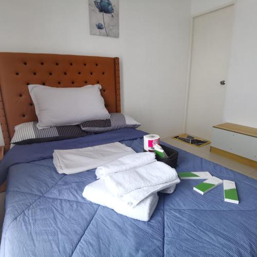 a bedroom with a bed with towels on it at Affordable Condo w/ Shower Heater and Wi-Fi in Minglanilla