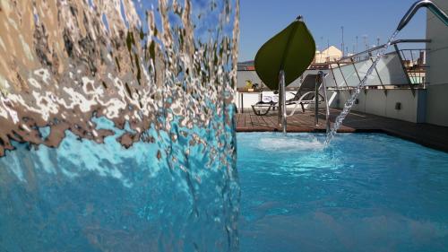 a swimming pool with water coming out of it at Ako Suite Hotel in Barcelona